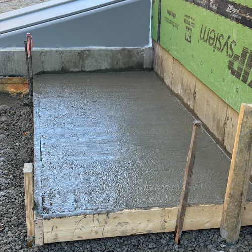 Freshly poured concrete slab with wooden formwork on construction site