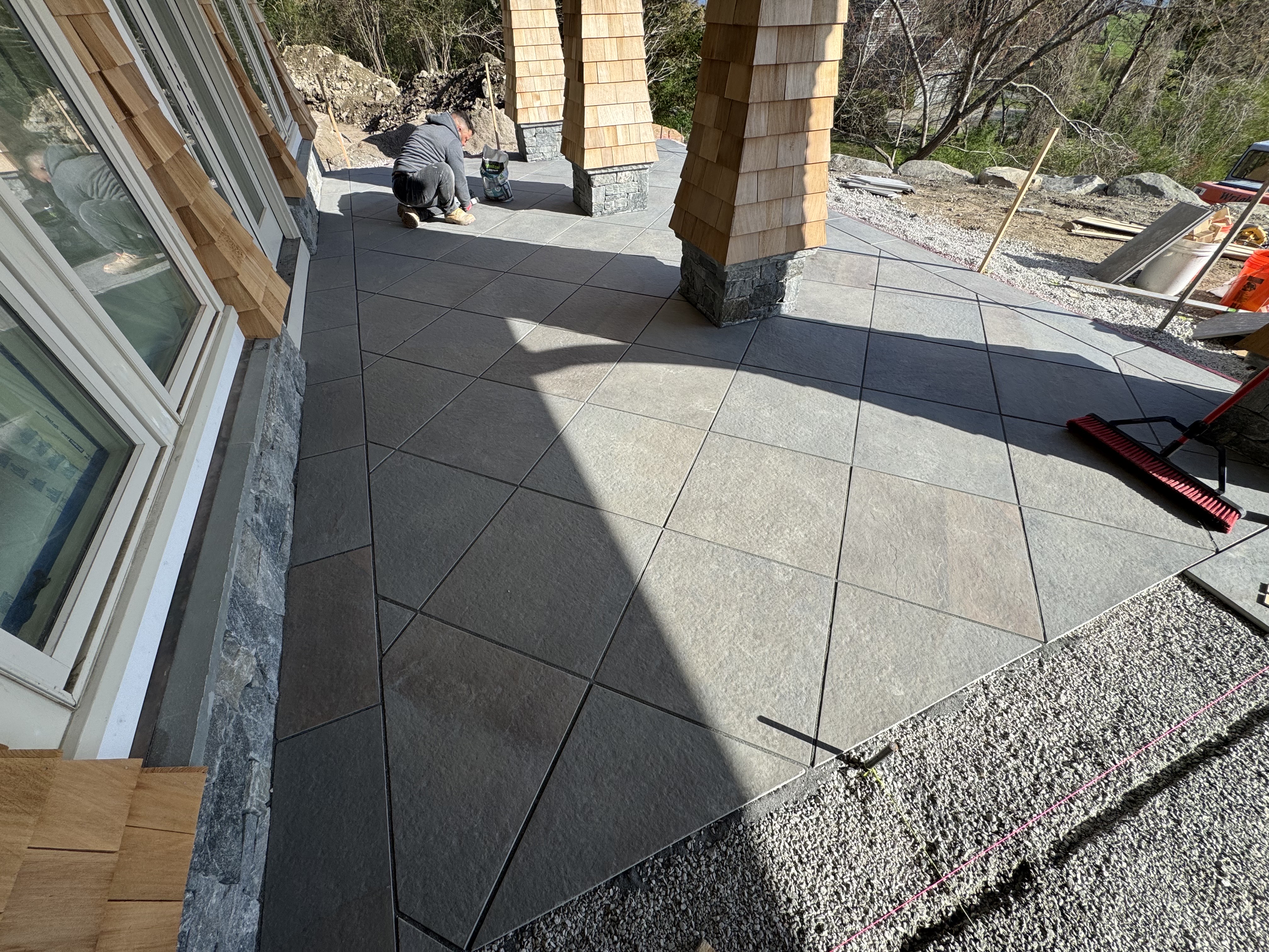 Geometric slate patio with stone columns during construction